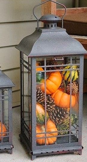 Pumpkins and pinecones inside a lantern